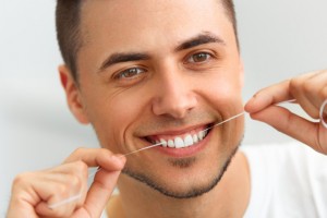 man flossing his teeth