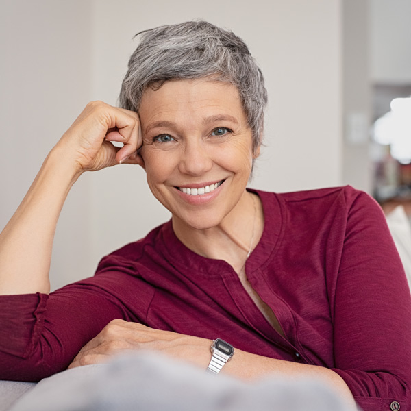 mature woman in berry colored shirt smiling