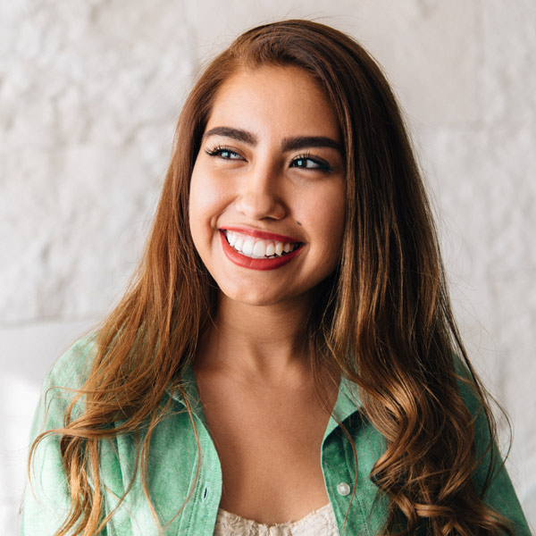 woman in green top with red lipstick smiling